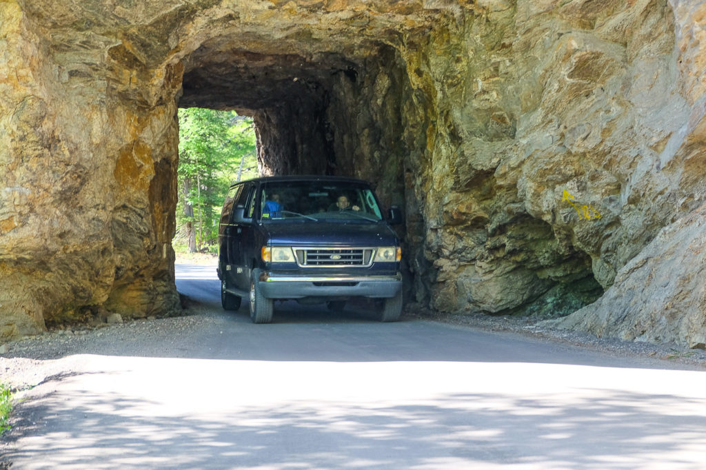 van going through tunnel on needles highway in Custer state park, South Dakota